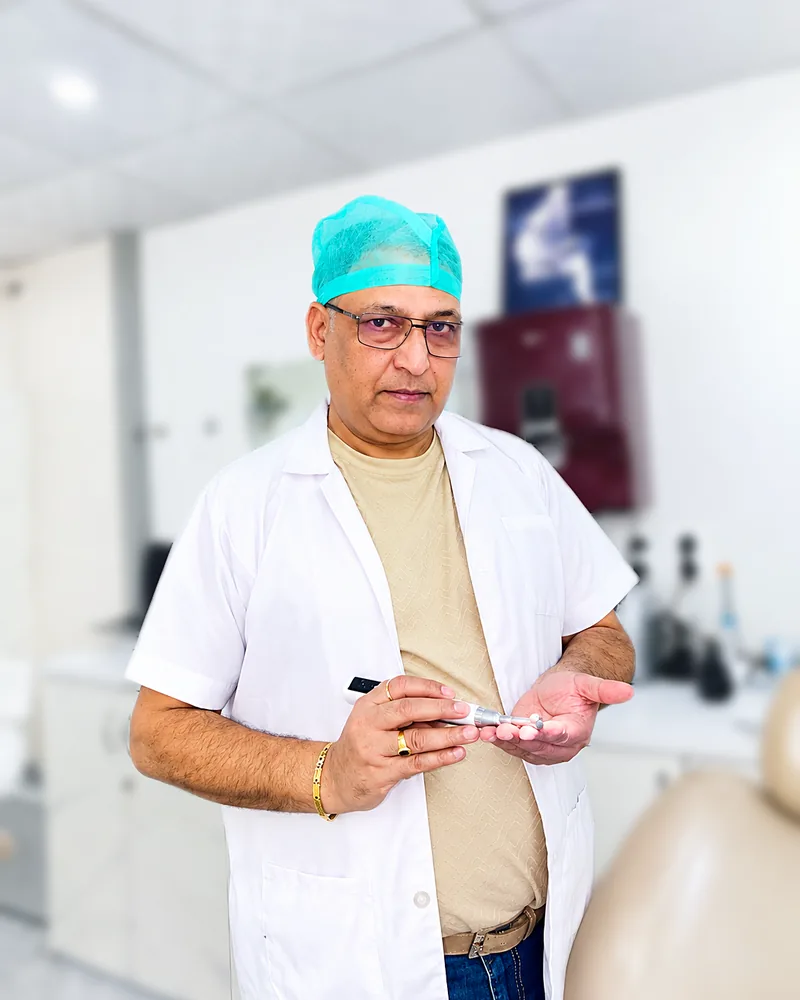 Dr. Mahendra Chaturvedi holding a dental handpiece